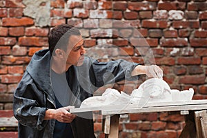 Craftsman restorer working with gypsum model