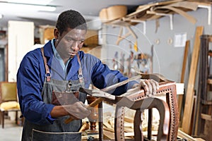 Craftsman restoring old chair in studio