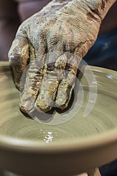 Craftsman\'s hand creating the art of ceramics in a pottery. Maragogipinho, Bahia, Brazil photo