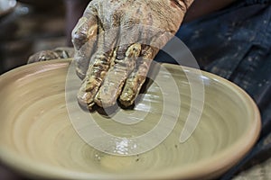 Craftsman\'s hand creating the art of ceramics in a pottery. Maragogipinho, Bahia, Brazil photo