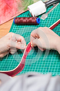 Craftsman sews belt for new leather bag
