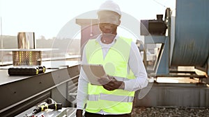 Craftsman standing and looking at wireless tablet outdoors