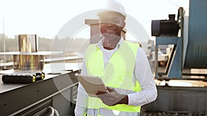 Craftsman standing and looking at wireless tablet outdoors