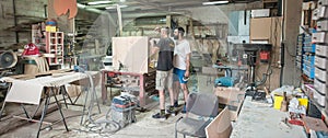 Craftsman using electric sander, to smoothen the wood texture photo