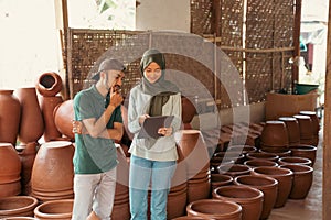 craftsman and veiled woman using pad at the pottery stall