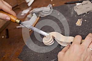 Craftsman violin maker carving a neck
