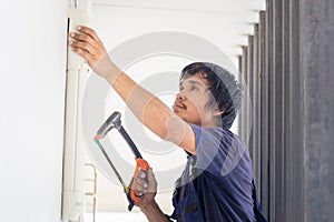 Craftsman worker sawing a pipe, Technician man installing an air conditioning in a client house, Young repairman fixing air