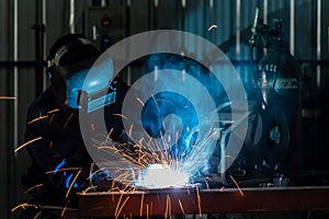 A craftsman or workers wearing industrial uniforms and welded iron mask at steel welding plants, Industrial safety first concept