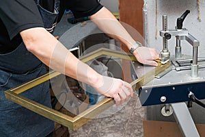 Craftsman working on frame in frameshop.
