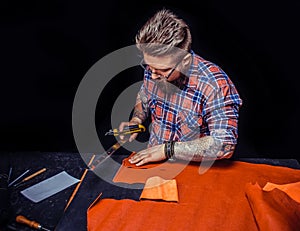 Craftsman working with leather working with leatherwork in leather studio