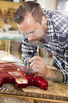 Craftsman working at workshop with musical instruments