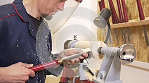 Craftsman in workwear working with spinning joinery using hand tool in carpentry workshop