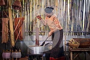 Craftsmen of Thai Silk. Older women dye silk with colors from volcanic soil. Phu fabric dyeing volcanic igneous or soil. Buriram,