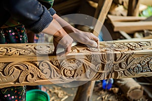 craftsperson carving intricate designs into timber beam