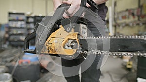 Craftsperson Starting Powered Chainsaw In Workshop