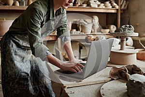 Craftsperson working on laptop in workshop