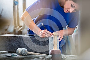 Craftswoman applying template for engraving on headstone