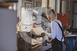 Craftswoman carving wood in a carpentry workshop