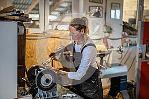 Craftswoman carving wood in a carpentry workshop