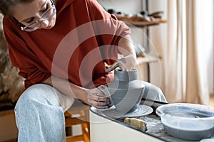 Craftswoman enjoying meditative process of making ceramics, shaping clay on pottery wheel