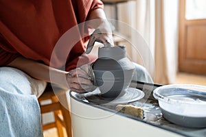 Craftswoman enjoying meditative process of making ceramics, shaping clay on pottery wheel