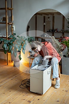 Craftswoman enjoying meditative process of making ceramics, shaping clay on pottery wheel