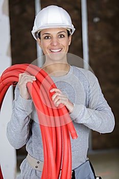 craftswoman holding red hose