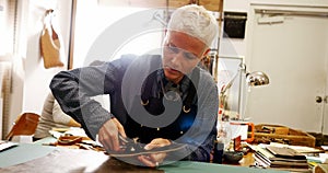 Craftswoman punching hole from leather punch machine