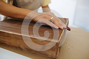 craftswoman sanding a wooden surface, close-up