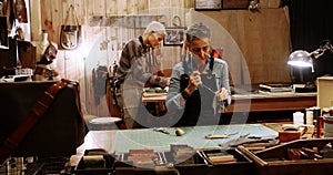 Craftswoman stitching a piece of leather