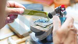 Craftswoman using blow torch on a equipment