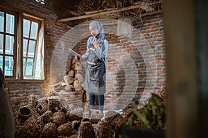 craftswoman in veil checking water hyacinth woven crafts