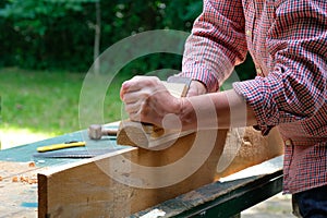 Craftswoman working with planer outdoors, close-up view. Woodworking, furniture production, carpentry concept