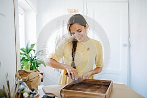 craftswoman works in her home studio, she sands a box