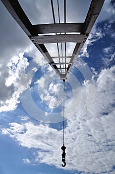 Crain with iron pendulum hook with blue sky.
