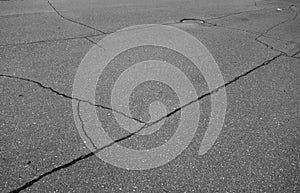 Craked asphalt and red manhole cover in black and white