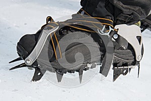 Crampons bite into hard snow. Climbing equipment.