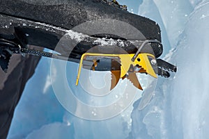 Crampons close-up on his feet ice climber, climber on a frozen waterfall.