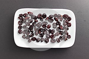 Cranberries on rectangular white plate with rounded corners.