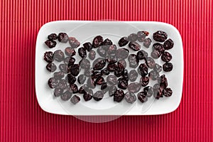 Cranberries on rectangular white plate with rounded corners.