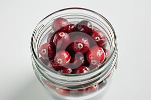 Cranberry closeup in a simple glass jar. White background