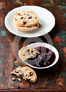 Cranberry cookies with jam on rustic wooden background. photo