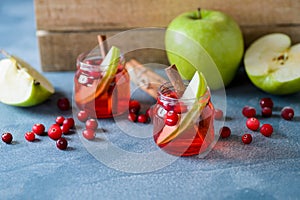 Cranberry drink with apples in glass cups.