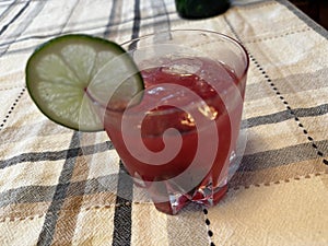 Cranberry, gin, cherry, slice lime garnish Cocktail on the rocks