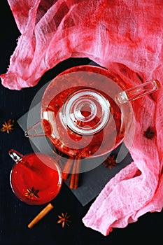 Cranberry herbal hot tea drink in glass teapot with cinnamon and