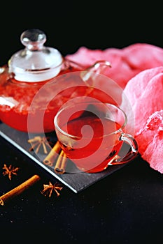 Cranberry herbal hot tea drink in glass teapot with cinnamon and