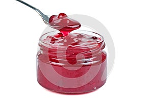 Cranberry jam in glass jare with spoon isolated on a white