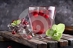 Cranberry juice with honey in a cup, cranberries in sugar. On a dark wooden background Copyspace