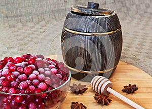 Cranberry on plate with anis, honney dipper and pot on table