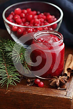 Cranberry sauce in a flas jar on rustic background, traditional holiday berry jam for christmas or thanksgiving